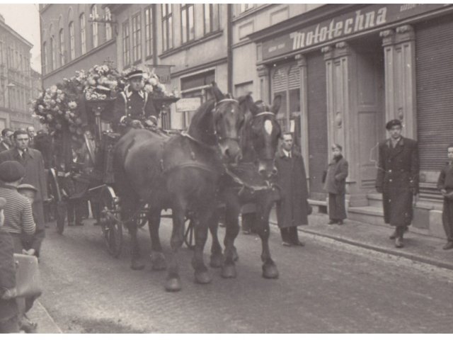 Pohřeb Jana Kupce. 
Pohřební kočár tažený koňmi před domem Jana Kupce v Sokolské ulici. Za kočárem šla dlouhá řada myslivců profesionálních i členů spolků.